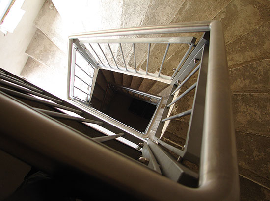Treppengeländer mit Edelstahlhandlauf, umlaufend über drei Etagen ausgeführt.
